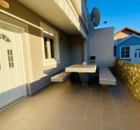 The family house in Nitra on Grbi Street has a terrace with a stone wall and a satellite dish.