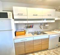 Kitchen in a family house with white cabinets, a stove, and a microwave.