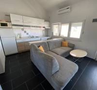 A kitchen with a corner sofa and a dining table, a family house, a floor with dark tiles.