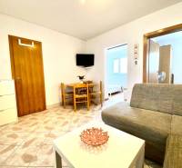 Living room in a family house with a sofa, a table, and a television on the wall.