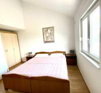 Bedroom in a family house with a double bed and a floor with a wooden decor.