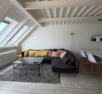 Living room with wood-patterned flooring, a sofa, and a dining table in a 4-room apartment.