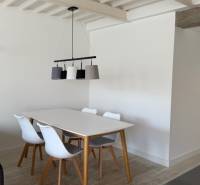 Dining table with chairs in a 4-room apartment, white walls, floor with wooden decor.