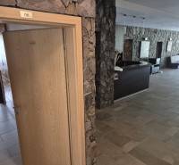 Stone walls and wooden doors leading to an office in a one-room apartment.