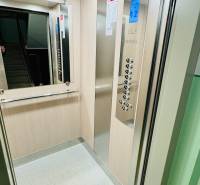 Interior of an elevator with a control panel and mirror, suitable for a 2-room apartment.