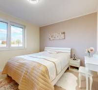 A bedroom in a family house with a bed, a dressing table, and soft colors.