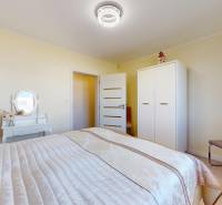 A bedroom with a bed, wardrobe, and dressing table in a family house.