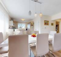 The dining room of a family house with a wooden decor floor and an elegant table in the center.