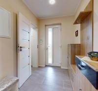 The entrance hall of a family house with tiles, decorative paintings, and storage space.