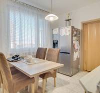 Kitchen in a 3-room apartment with a dining table and a refrigerator.