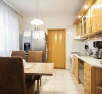 A kitchen in a 3-room apartment with a dining table, appliances, and light-colored furniture.