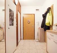 The entrance hall of a 3-room apartment with tiles and storage cabinets.