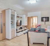 A living room in a 3-room apartment with a wooden decor floor and a corner sofa.