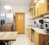 A kitchen in a 3-room apartment, equipped with wooden cabinets and built-in appliances.