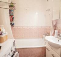 Bathroom in a 3-room apartment with a bathtub, sink, washing machine, and storage spaces.