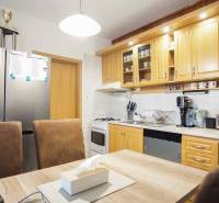 A kitchen in a 3-room apartment with wooden cabinets and modern equipment.