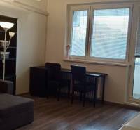 Living room in a two-room apartment with a corner sofa and a floor with a wooden decor.