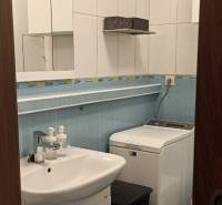Bathroom with a sink, mirror, and washing machine in a 2-room apartment.