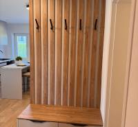 An entrance hall in a 2-room apartment with a slat wall and a chest of drawers with storage space.