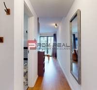 A hallway in a 2-room apartment with a large mirror and a floor with a wooden decor.
