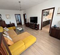 Living room in a 3-room apartment, yellow sofa, wood floor decor, spacious interior.