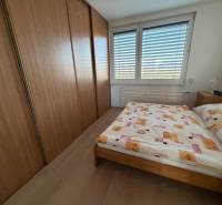 Bedroom in a 3-room apartment with a large wardrobe and bed, floor with wooden decor.