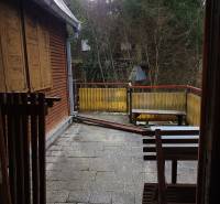 Terasa chaty na Výtockej ulici, Moravany nad Váhom s dreveným dekorom a okolitou zeleňou.