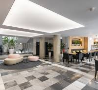 Offices with black and white flooring, columns, seating, and a café in the interior.