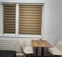 Dining area with a wooden table and two white chairs in a studio apartment.