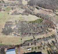 Aerial view of extensive residential lands in Krupina, with forests and fields.