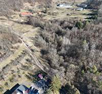 Aerial view of residential plots in Krupina surrounded by forest vegetation.