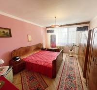 Bedroom in a 3-room apartment with red accessories and a floor with a wood decor.