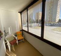 Glazed loggia in a 3-room apartment with a street view, equipped with armchairs.