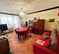 Living room in a 3-room apartment with carpeted flooring and wooden furniture.