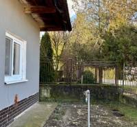 A family house in Mýtne Ludany with a side garden and lawn, surrounded by a fence.