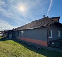 A family house in Mýtne Ludany with a grassy garden and a brick facade.