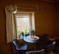 Dining area in a family house with patterned flooring and chairs around a round table.