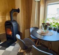 Fireplace in the living room of a family house with a round table and two chairs.