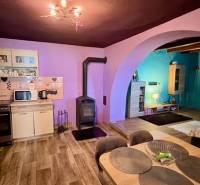 Kitchen and living room in a family house with a wooden decor floor and a fireplace.