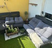 The 3-room apartment has a terrace with pallet furniture, cushions, and plants on artificial grass.