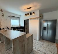 A kitchen in a 3-room apartment with a counter and a wooden decor floor.