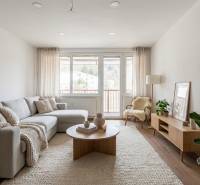 Living room in a three-room apartment with a wooden decor floor, light furniture, plants.