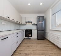 A kitchen in a 3-room apartment with a wooden decor floor and equipment.