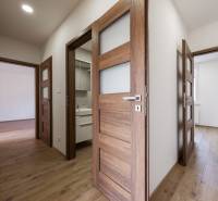 Interior of a 3-room apartment with wooden doors and a floor with a wood decor.