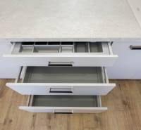 Opening kitchen drawers in a 3-room apartment with a countertop and floor with wood decor.