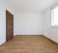 White wall, window, wooden door, and floor with wooden decor in a 3-room apartment.