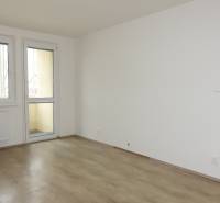 A room with a wooden floor design in a 3-room apartment, a table and a chair.