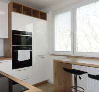 Kitchen in a 3-room apartment with white cabinets and a wood-patterned floor.
