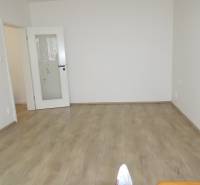 A room in a 3-room apartment with white walls and a wooden decor floor.