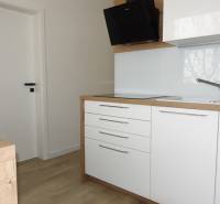 A kitchen unit with a wooden decor floor in a 3-room apartment.